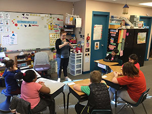 Early years students listen attentively to a teacher